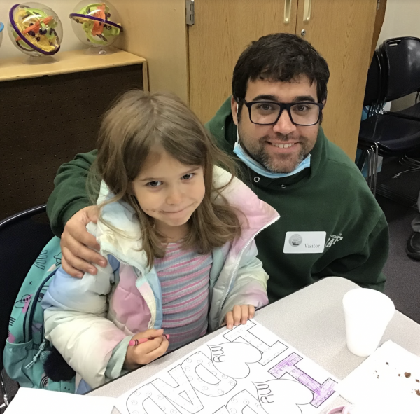 student with Dad at Donuts for Dads breakfast